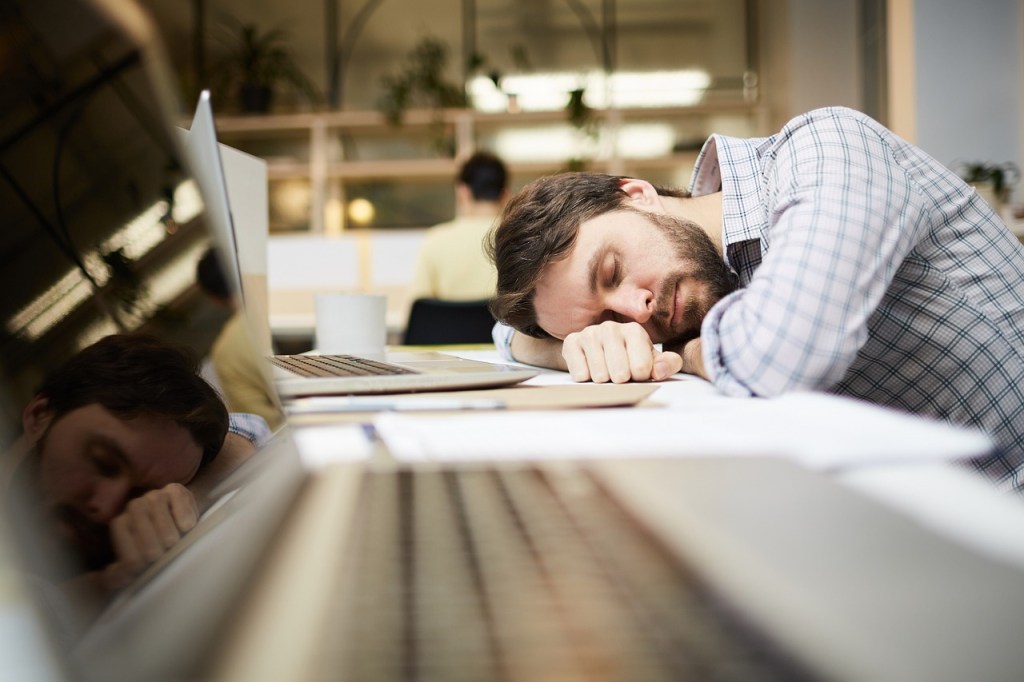 man lying on desk, man sleeping on desk with computer