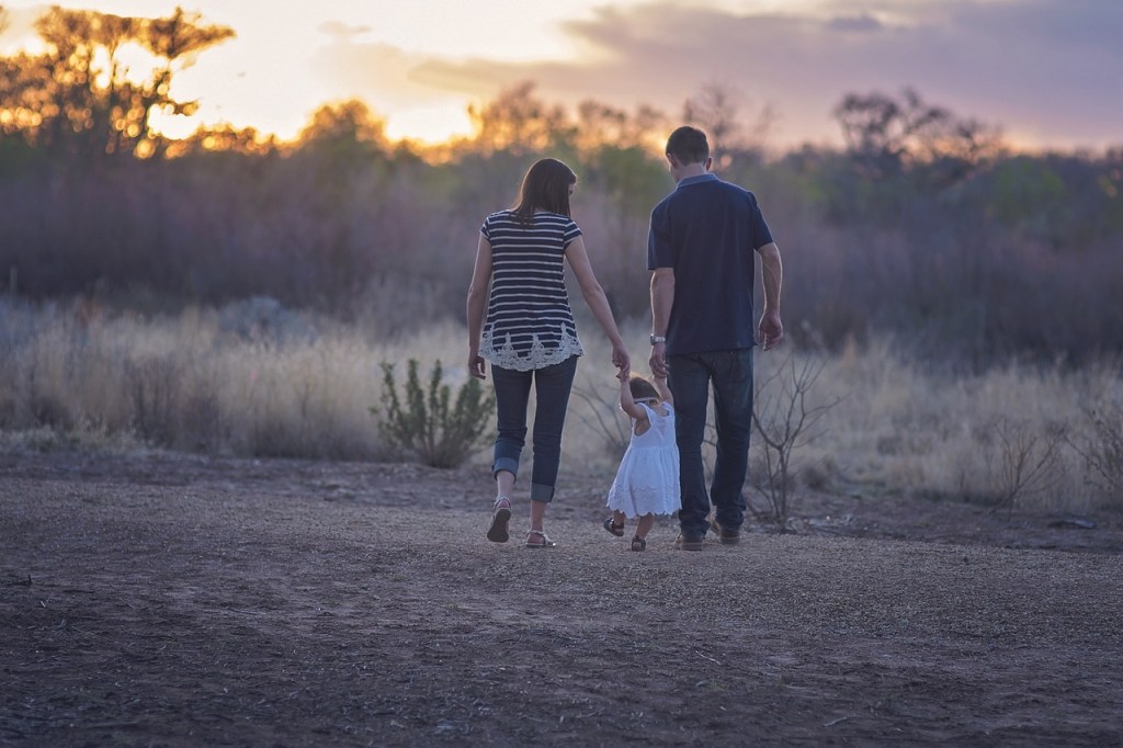 family walking in sunset in a field